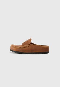 Brun läder slip-on sko med rundad front, synliga sömmar och gummisula. Slät textur och minimalistisk design.