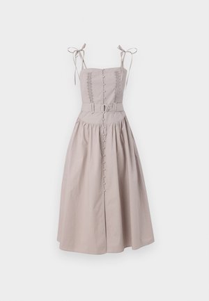 Robe beige clair avec un corsage ajusté, des garnitures en dentelle et des bretelles réglables. Présente une ceinture avec une boucle en métal et un devant à boutons.