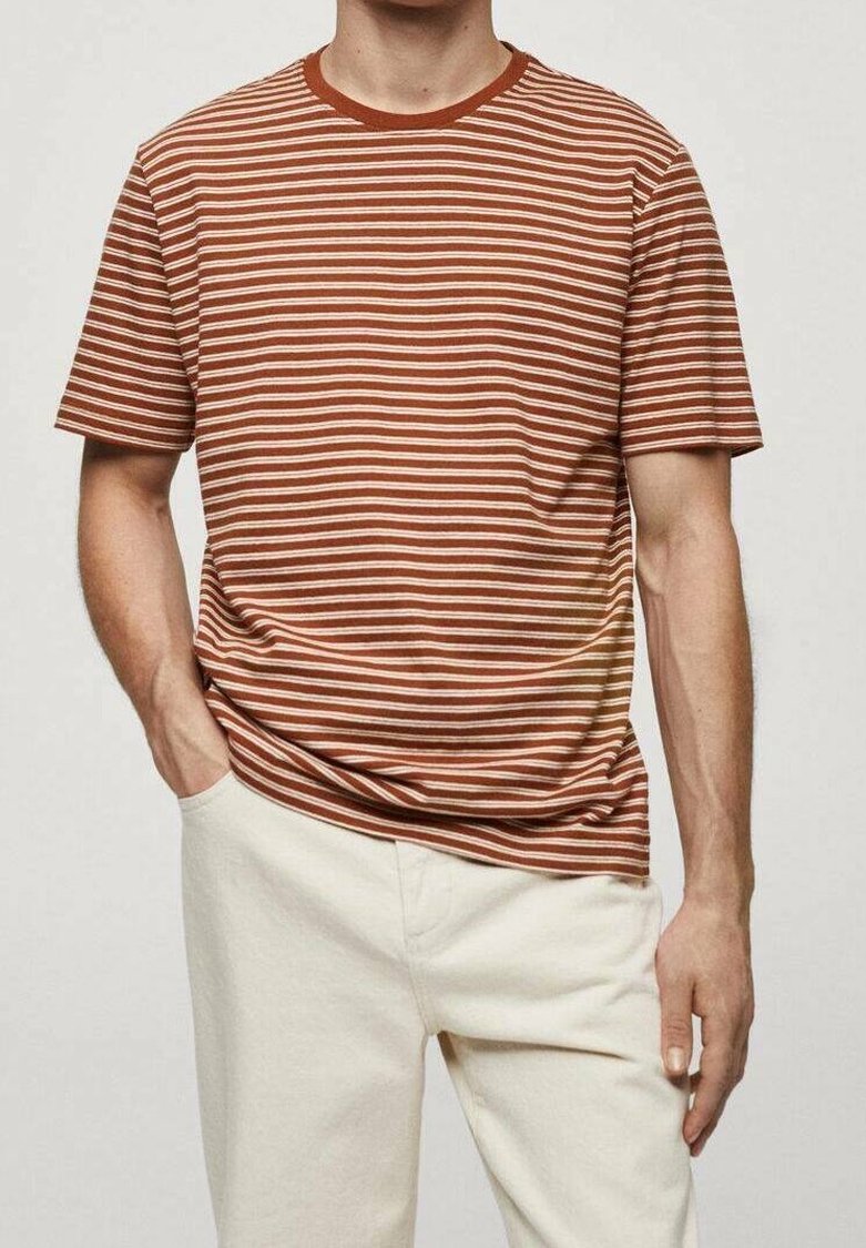 Camiseta de manga corta a rayas marrón y crema con cuello redondo, combinada con pantalones de color claro. La tela parece suave y casual.