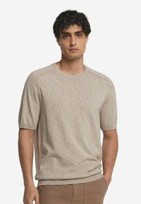 Beige kortærmet t-shirt lavet af tekstureret stof, med en rund hals og ribbede manchetter, i en afslappet pasform og en subtil meleret mønster.