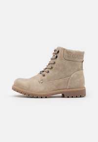 Bottine beige à lacets avec semelle robuste, œillets en métal et détails cousus, montrant le profil latéral sur fond blanc.