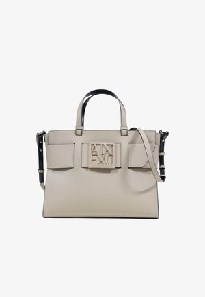 Bolso tote beige con cuero de textura suave, dos asas y una correa ajustable para el hombro. Cuenta con un logo destacado y dos bolsillos frontales.