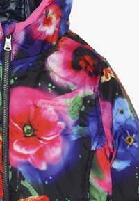 Pufová bunda s květinovým vzorem na černém pozadí, se zářivými růžovými, červenými a modrými květy; obsahuje zipové zapínání a logo štítek.