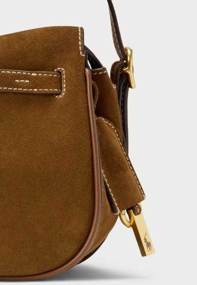 Bolsa de ombro em suede castanho com acabamentos em pele, ferragens em tom dourado, alça plana e costura em contraste. Apresenta uma pequena etiqueta de logotipo pendurada.