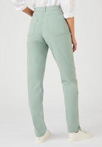 Lichtgroene high-waisted jeans met een rechte pasvorm, featuring opgestikte zakken achter en opgerolde boorden, gemaakt van een gladde katoenmix.