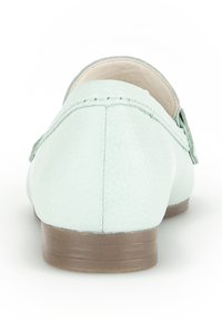 Lichtgroene leren instappers met een ronde neus, een gestructureerde afwerking en een lage bruine zool. Inclusief stiksel langs de achterkant.