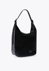 Borsa a spalla in suede nera con una forma curvata, texture liscia e un dettaglio del logo decorativo. Presenta un'unica tracolla in pelle regolabile.