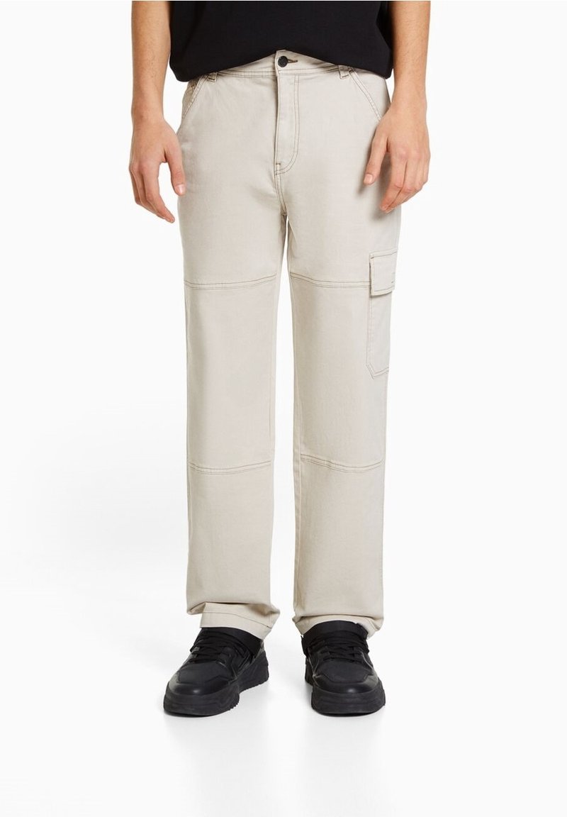 Beige cargo pants with a straight leg design, patch pockets on the side, made of durable cotton blend, featuring stitched accents.