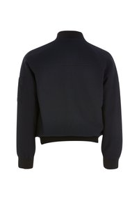 Marinblå bombarjacka med en strukturerad mönster, ribbad krage och ärmslut, samt en kort passar. Inkluderar en sidoficka på ärmen.