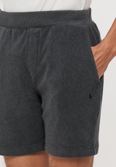 Șorturi gri din bumbac cu talie elastică, buzunare laterale și un mic logo brodat pe piciorul stâng. Textură netedă și design casual.