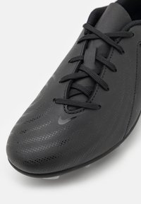 Svart fotballsko med teksturert overflate, med et slankt design, rund tå og svarte lisser. Subtil merkevaredetalj på siden.
