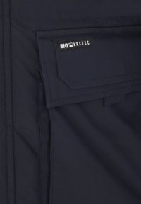 Tengerészkék dzseki anyag, varrott részletekkel, oldalsó zsebflappal és „MO ARCTIC” márkajelzéssel. Vízálló anyag sima textúrával.