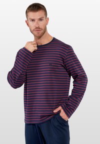 Marineblå og bordeaux-stribet langærmet skjorte med rund halsudskæring, blød tekstur, der har et lille logo på brystet. Casual pasform.