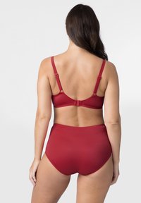Sarkans bikini komplekts, kas sastāv no pieguļošas aizmugures krūštura ar regulējamiem siksniņām un atbilstošiem augstiem apakšbiksēm. Gluda tekstūra un minimālas detaļas.