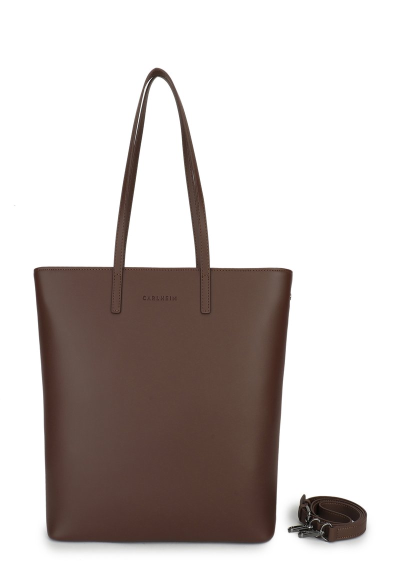 Sac fourre-tout en cuir marron avec deux longues poignées, design minimaliste, forme carrée, base plate et bandoulière amovible. Présente un logo en relief.