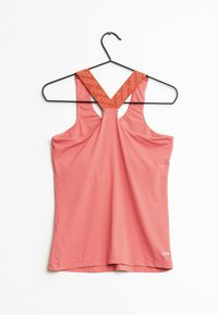 Light pink athletic tank top with a crisscross back. Features a contrasting strap with "Reebok" logo. Made of smooth, stretchy fabric.