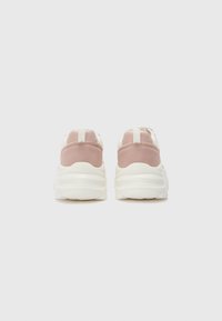 Sneaker in suede rosa e rete bianca con suola spessa, linguetta sul retro e dettagli testurizzati nella parte superiore, viste da dietro.