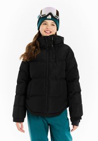 Zwarte pufferjack met een hoge kraag en ritssluiting, met een gladde textuur. Draagt een teal sneeuwbroek en een teal gebreide muts.