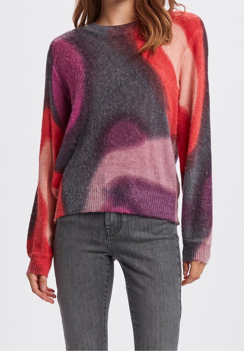 Pull en tricot présentant un mélange de couleurs rouge, rose, gris et violet, avec une coupe décontractée et des manches longues. Texture douce et ourlet côtelé.