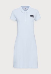 Světle mod dress polo s krátkými rukávy, límečkem, knoflíkovou légou a námořnickou nášivkou na hrudi. Vyrobeno z měkkého bavlněného materiálu.