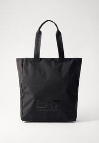 Juodas rankinės krepšys, pagamintas iš patvarios medžiagos, turi du stiprius rankenėles. Ant priekio iškilminis EA7 Emporio Armani logotipas. Paprastas, stačiakampio formos dizainas.