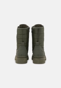 Bottes isolantes vertes avec un design matelassé, dotées d'une fermeture éclair latérale et de semelles texturées pour une meilleure adhérence. Doublure douce et accents en caoutchouc solide.