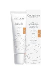 Korrigierende Make-up-Flüssigkeit in einer weißen Tube mit geschwungenen Designelementen. Verfügt über SPF 20, einen hellen Honigton und eine Verpackung mit mehrsprachigem Text.