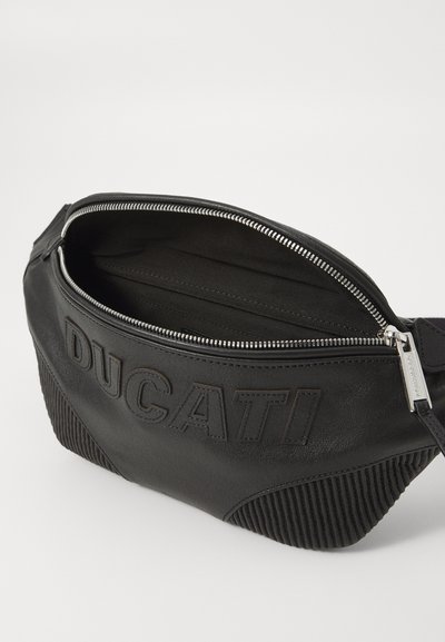 Sort lædertaske med ribbede detaljer, top lynlås lukning og præget "DUCATI" logo på forsiden. Indersiden har flere rum.