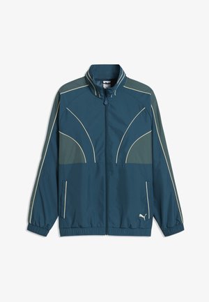 Blau-grüne Trainingsjacke mit Reißverschluss, hellen Paspel-Details, elastischen Bündchen und Saum, Fronttaschen und kleinem Puma-Logo vorne unten.