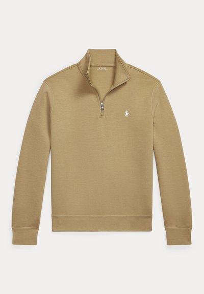Smėlio spalvos megztinis su ilgomis rankovėmis, ketvirtine užtrauktuku ir mažu baltu Polo Ralph Lauren logotipu kairėje krūtinės pusėje.