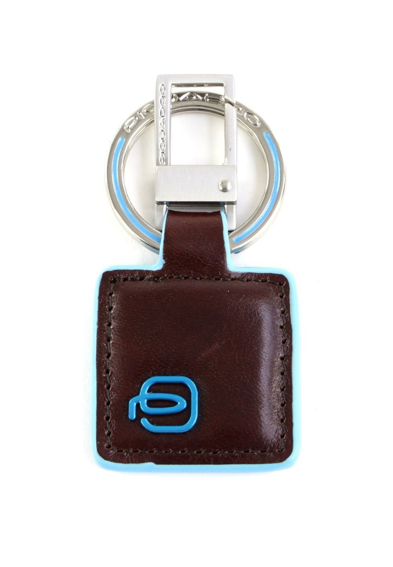Portachiavi in pelle marrone con accenti azzurri, etichetta rettangolare e anello circolare in metallo argento. Logo impresso in blu sull'etichetta.