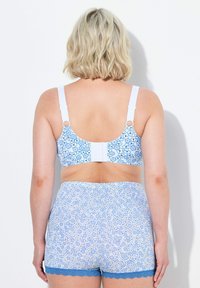 Ljust blå blommönstrad bh och matchande shorts med scalloped spetsdetaljer, med justerbara vita remmar och krok-och-ögla-stängning.