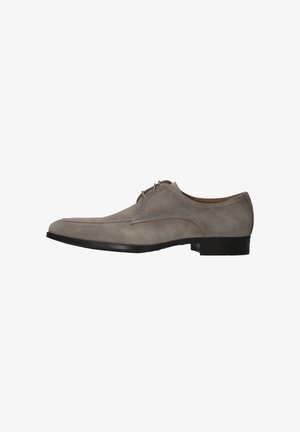 Chaussure habillée homme en daim gris avec fermeture à lacets et petit talon noir, vue de profil sur fond blanc.