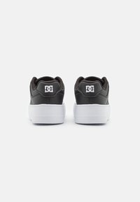 Schwarze Leder-Skate-Schuhe mit einer weißen Gummisohle. Mit gepolstertem Kragen und Ferse sowie einem weißen DC-Logo an der Außenseite.