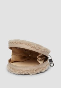 Beige runder Münzbeutel mit Reißverschluss, weicher, strukturierter Außenseite und kleinem Innenfach auf einem schlichten Hintergrund.