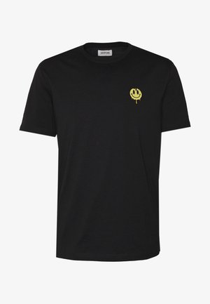 T-shirt en coton noir avec un petit graphique de smiley jaune au motif dégoulinant sur la partie gauche de la poitrine. Design à manches courtes et col rond.