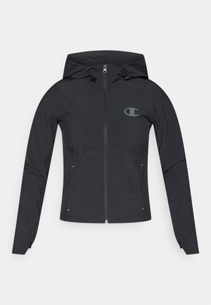 Črna zip-up jakna s kapuco, ki ima logo na prsih, izdelana iz gladkega, lahkega materiala; vključuje vrvice in prilega.