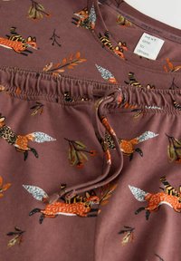 Brown cotton top with fox and leaf patterns, featuring a rounded neckline and gathered waist with a drawstring detail.