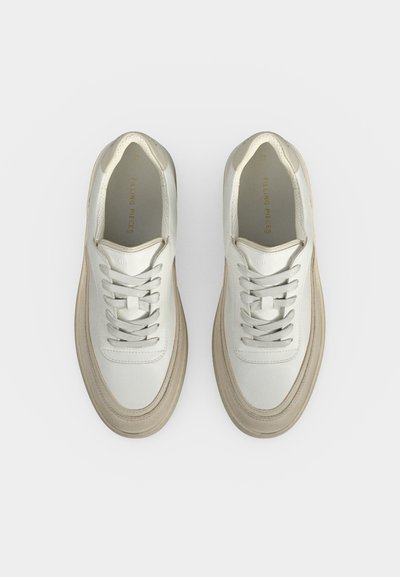 Paire de baskets en cuir blanc avec semelles et lacets beiges, vues de dessus sur un fond blanc uni.