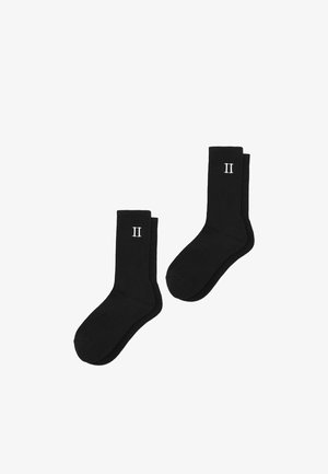 Schwarze gerippte Socken mit einer weißen "II"-Aufdruck auf der oberen Hälfte. Weicher Stoff mit einer standardmäßigen Crew-Länge.