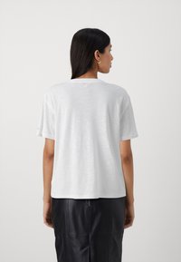 Hvid kortærmet t-shirt i en afslappet pasform, med rund halsudskæring og en blød, let tekstur. Ingen synlige mønstre eller logoer.