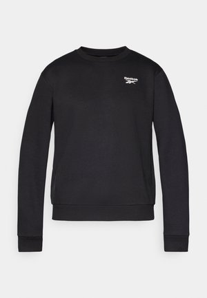 Melnas kokvilnas sporta krekls ar garām piedurknēm, apaļu kakla izgriezumu un ribotām piedurknēm. Kreklam ir balts Reebok logo augšējā kreisajā krūšu daļā.