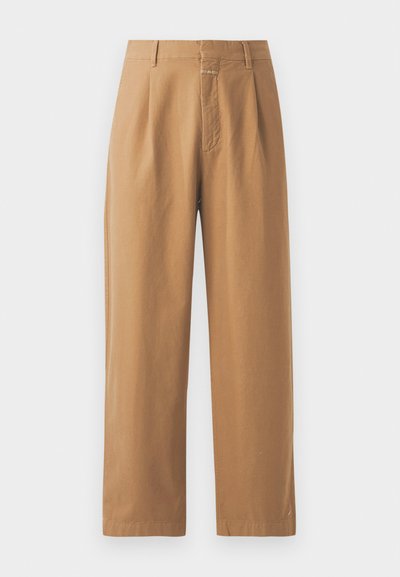 Brune, vide benbukser laget av glatt stoff. Har høy midje med legg, beltesløyfer og en enkelt frontlomme.