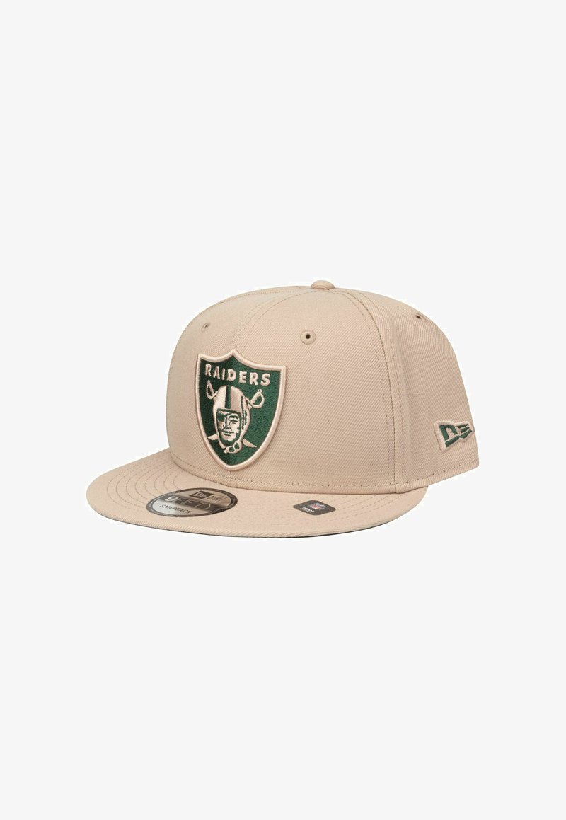 Beige Baseballcap mit flachem Schirm, ausgestattet mit einem grün-schwarzen, gestickten Raiders-Logo auf der Vorderseite und einem New Era-Logo an der Seite.
