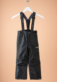 Pantalon de neige noir imperméable avec bretelles réglables aux épaules, poches avant et fermeture par boutons, suspendu sur un cintre blanc.