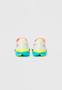 Baskets de course blanches avec une tige en mesh, accents orange vif et vert fluo, et une semelle turquoise. Présente un logo sur les talons.