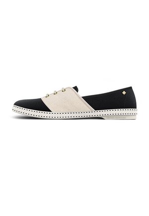 Chaussures noires et beiges à enfiler avec une finition texturée, comportant trois œillets décoratifs et une semelle en caoutchouc contrastante avec un bord fantaisie.