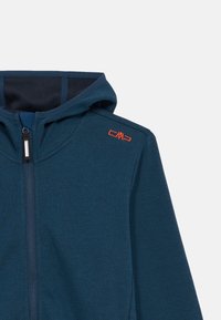 Σκούρο μπλε φούτερ με φερμούρ, φτιαγμένο από υφή υφάσματος, με κανονισμένη κουκούλα και αντίθετη εσωτερική επένδυση. Διαθέτει πορτοκαλί λογότυπο στον ώμο.