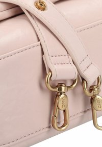 Roze blush leren handtas met goudkleurige accenten, voorzien van dubbele sluitclips en gestikte details op de band. Gladde textuur.