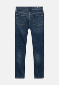 Jeans de mezclilla azul oscuro con un diseño de pierna recta, que cuentan con dos bolsillos traseros y un ligero desvanecimiento en la tela, sin herrajes ni acentos visibles.